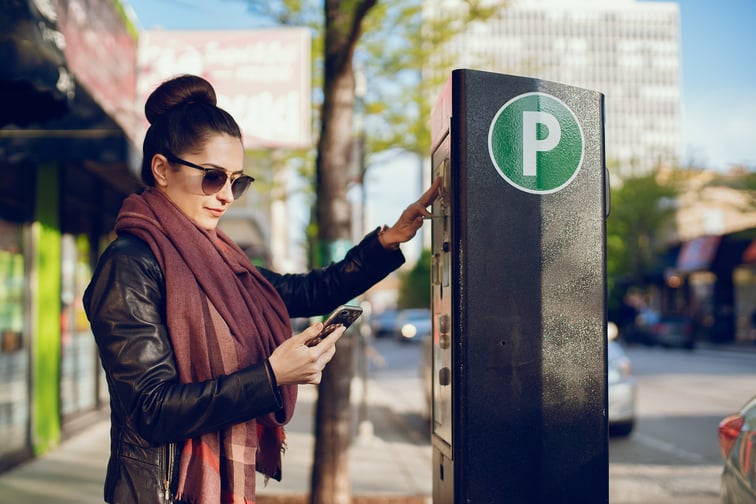 beautiful-young-woman-pays-parking-meter-street