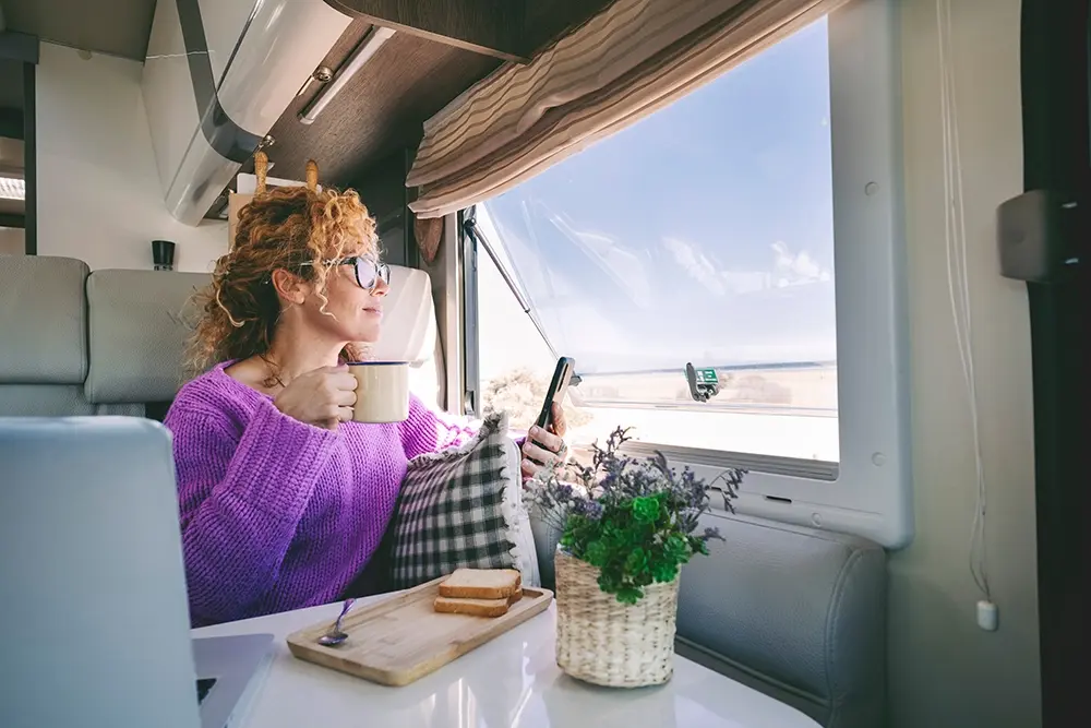 Femme qui regarde par la fenêtre de son camping-car