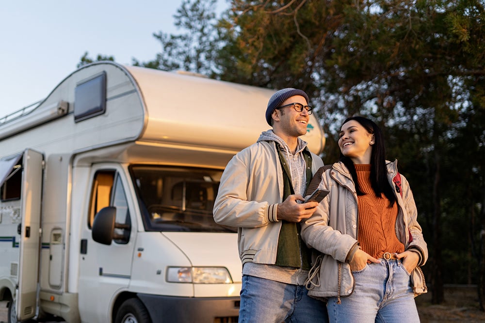 Un jeune couple devant un camping-car